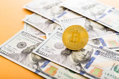 ABD doları üzerindeki Altın Bitcoin madeni para. Fotokopi alanı ile turuncu arkaplanı kapatın..