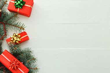 Xmas Yeni Yıl 2020 Noel kutlama şablonu kırmızı hediye kutularından, köknar dallarından, beyaz ahşap arka planda balolardan oluşur. Noel zamanı ve kışı düşünün. Düz konum, üst görünüm, kopyalama alanı