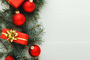 Xmas Yeni Yıl 2020 Noel kutlama şablonu kırmızı hediye kutularından, köknar dallarından, beyaz ahşap arka planda balolardan oluşur. Noel zamanı ve kışı düşünün. Düz konum, üst görünüm, kopyalama alanı