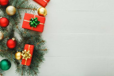 Xmas Yeni Yıl 2020 Noel kutlama şablonu kırmızı hediye kutularından, köknar dallarından, beyaz ahşap arka planda balolardan oluşur. Noel zamanı ve kışı düşünün. Düz konum, üst görünüm, kopyalama alanı