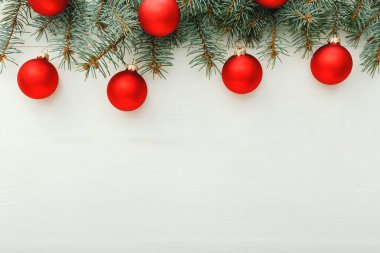 Xmas Yeni Yıl 2020 Noel kutlama şablonu kırmızı toplardan oluşuyor, köknar dalları beyaz ahşap arka planda. Noel zamanı, kış. Düz konum, üst görünüm, kopyalama alanı