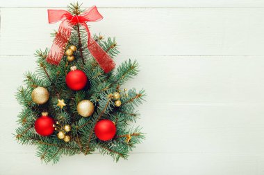 Xmas Yeni Yıl şablonu kompozisyonu: Köknar dallarından yapılmış Noel Ağacı, kırmızı, beyaz ahşap arka planda altın toplar, bayram kutlaması konsepti 2020. Düz konum, üst görünüm, kopyalama alanı.