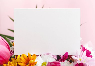 Çiçekler tebrik taklidi yapar. Pembe arka planda bir buket çiçekli tebrik kartı. Metin, çerçeve modeli için yeri olan beyaz boş kart. Bahar festivali çiçek konsepti, hediye kartı