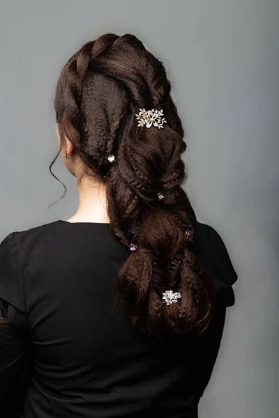 辫子尾毛风格 棕色头发女人的发型 灰色背景的长发 专业美发服务 发型师 用发夹做辫子 — 图库照片