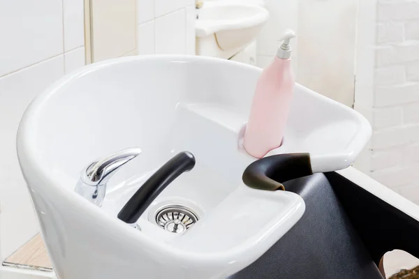 Hair wash sink for washing hair in beauty salon interior or Barber shop, shampoos hair cosmetics for spa treatment. Hairdresser stylist work space. Hairdressing bowl, washer equipment