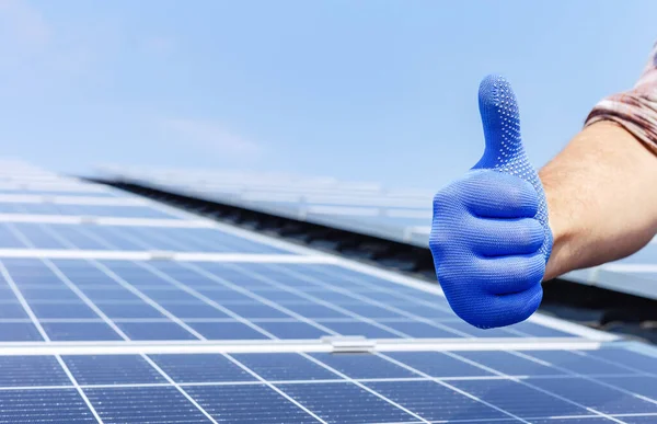 Männlicher Arbeiter zeigt Daumen hoch, positive Geste gegen Solarmodul, Solarstation. Wie bei der alternativen Energie Sonnenenergie. Mann installiert Sonnenkollektoren auf Hausdach. Nahaufnahme aus dem Kopierraum — Stockfoto