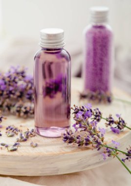 Beyaz ahşap tahta tahtada şişelerde lavanta banyosu kozmetik ürünleri, taze lavanta çiçekleri, mum, sabun, banyo boncukları, lavanta yağı, doğal spa ürünleri. Aromaterapi tedavisi.