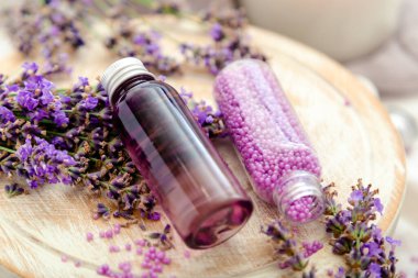 Beyaz ahşap tahta tahtada şişelerde lavanta banyosu kozmetik ürünleri taze lavanta çiçekleri, sabun, banyo boncukları. Lavanta yağı, doğal spa ürünleri. Aromaterapi tedavisi.
