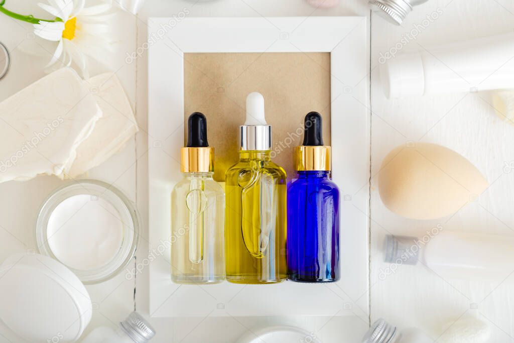 Serum oil dropper glass bottle set. Skincare hair treatment cosmetic for beauty face. Different types of oil and serum mockup on white background. Top view Flat lay.