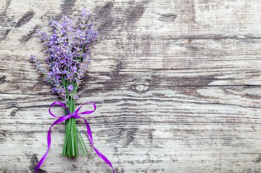 Eski ahşap masa üzerinde taze lavanta çiçekleri. Flatlay mor bitkisel çiçek çiçeği. Bir demet lavanta. Kurdeleyle tutturulmuş. Kopya alanı da metin için. Lavanta aromaterapisi.