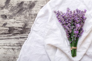 Taze lavanta çiçeği buketi eski ahşap kumaş üzerinde. Flatlay mor bitkisel çiçek çiçeği. Metin için fotokopi alanı olan bir demet lavanta. Lavanta aromaterapisi. Kurutulmuş lavanta çiçekleri