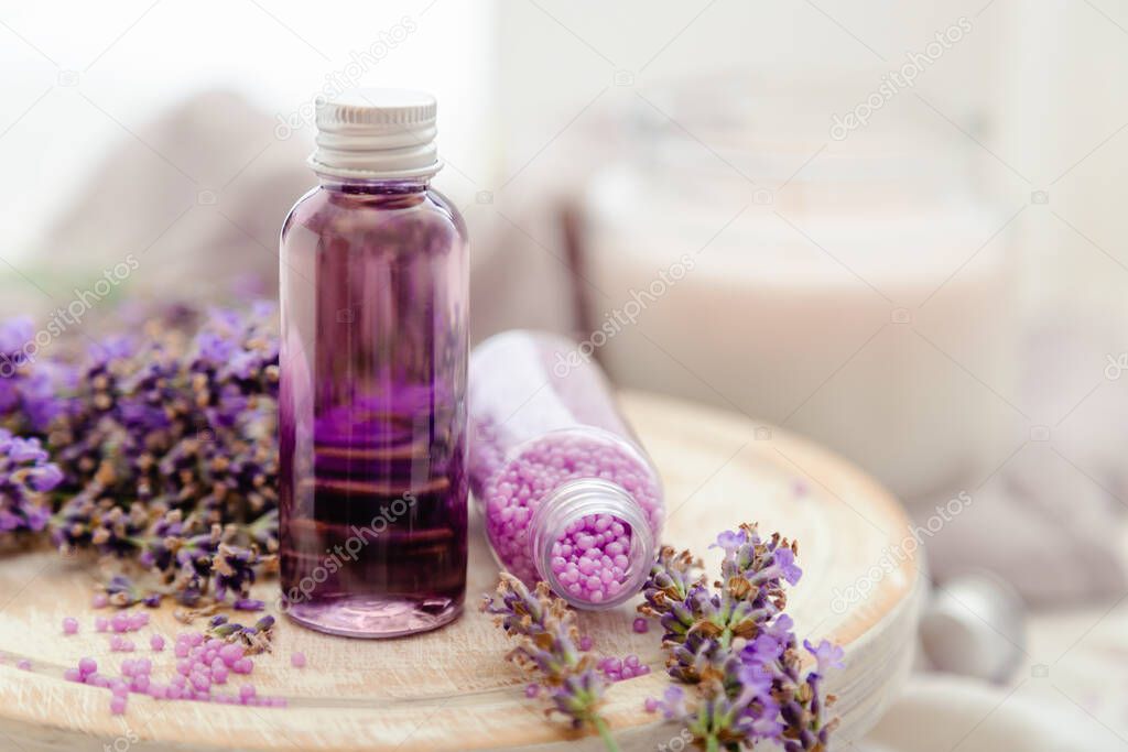 Set lavender bath cosmetics products in bottles with fresh lavender flowers candle soap bath beads. Lavender essential oil, natural spa products.Aromatherapy treatment Copy space