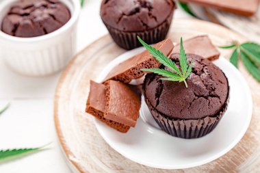 Marihuana çikolatalı kek ve ot CD 'si. Tıbbi marihuana, tatlı olarak kenevir ilacı. Tabakta esrar, süt çikolatası ve kenevir yapraklı esrarlı çörekler servis ediliyor..