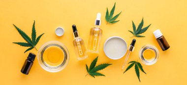 Kenevir CBD yağları, temel yağ, sarı arka planda serum yağı uzun afişi. Kenevir tentürü. Kenevir kozmetik ürünlerini tıbbi esrarla ayarla. Sarı arkaplanda uzun web pankartı