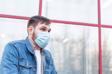 Avrupa koronavirüsü. Yüz hijyenik maskesi takan beyaz bir adamın portresi, açık havada solunum koruma maskesi. Virüs, koronavirüs koruması, hava kirliliği, ekoloji, çevre bilinci