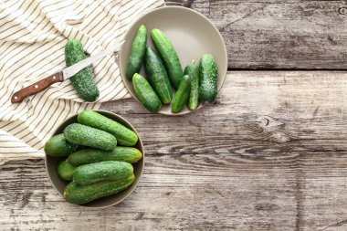 Kırsal tabaklarda taze çiftlik salatalıkları ve bıçak, havluda salatalık, ahşap masa, kopyalama alanı..