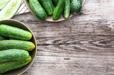 Kırsal tabaklarda taze çiftlik salatalıkları ve havlunun üzerinde doğranmış salatalıklar, ahşap masa, kopyalama alanı..