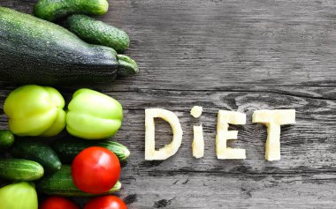 Üst düzey diyet harfleri sebzeler, kabak harfleri, domates, salatalık, dolmalık biber, kabak içerir. Sağlıklı, vejetaryen, çiftlik, doğal, eko, böcek ilacı, ahşap arka planda.