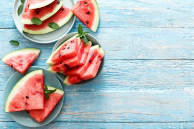 Mavi tabakta naneli taze kırmızı dilimlenmiş olgun karpuz. Üst görünüm uzayı kopyalayabilir. Yaz konsepti