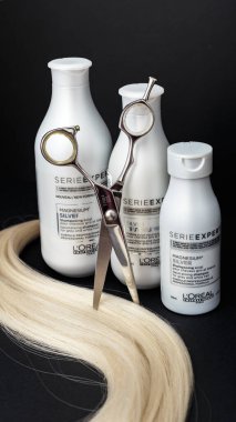 L 'oreal Profesnel Paris Serie Uzmanı Gümüş Saçlı Profesyonel Yapımcılar. Gri beyaz saçlar için Loreal şampuan kremi maskesi. Profesyonel kuaför makası ve siyah arka planda sarı saç tutamı..