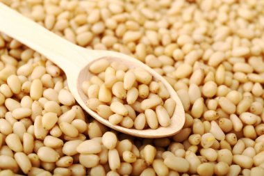 Ahşap kaşıkta çam fıstığı kabuklu çam fıstığı dokusunda