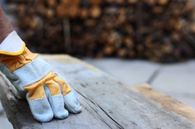 Marangoz eldiveni marangozluk atölyesindeki ahşap kalasın üzerindeydi. Yakın çekim..