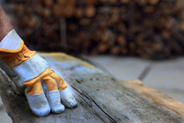 Marangoz eldiveni marangozluk atölyesindeki ahşap kalasın üzerindeydi. Yakın çekim..