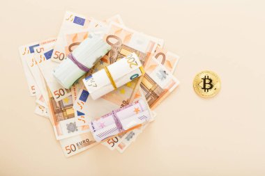 Arka planda avro banknotları olan altın bitcoinler. Sanal kripto para birimi, dijital konsept