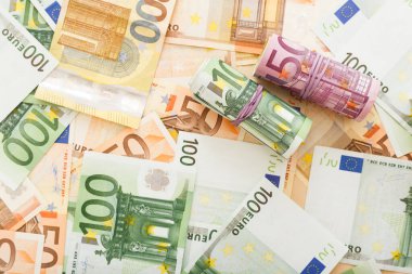 Avro banknotları etrafa saçılmış avro paralarıyla dolu. İş, finans, tasarruf, bankacılık konsepti, döviz kuru. Çerçeve, kopyalama alanı, üst görünüm