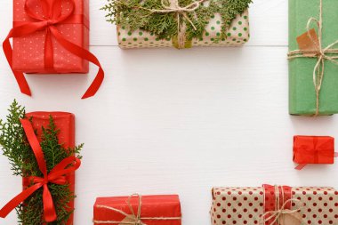 Noel çerçevesi kırmızı, yeşil, kahverengi el yapımı Noel hediyeleri beyaz ahşap masa arka planında. Noel, Noel, kış, yeni yıl konsepti. Düz konum, çerçeve, üst görünüm, boşluk kopyala.