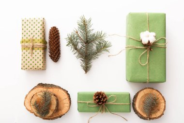 Çam kozalaklarından, dallardan, mumlardan, ağaç halkalarından yapılmış sıfır atık Noel kompozisyonu, beyaz masada naylon olmayan el yapımı hediyeler. Üst görünüm, kapat, boşluğu kopyala, arkaplan, düzleştir.