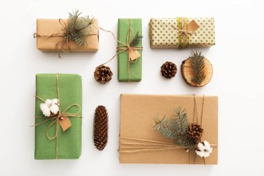 Çam kozalaklarından, dallardan, mumlardan, ağaç halkalarından yapılmış sıfır atık Noel kompozisyonu, beyaz masada naylon olmayan el yapımı hediyeler. Üst görünüm, kapat, boşluğu kopyala, arkaplan, düzleştir.