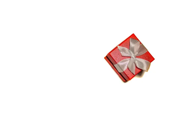 A beautiful red box with a white ribbon. Packaging for a gift on — Stock Photo, Image