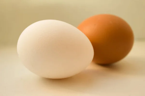 Két tojást fehér háttér meleg színek — Stock Fotó