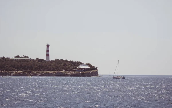 Uitzicht Kust Vuurtoren Een Wolkenloze Dag Het Jacht Drijven Buurt — Stockfoto