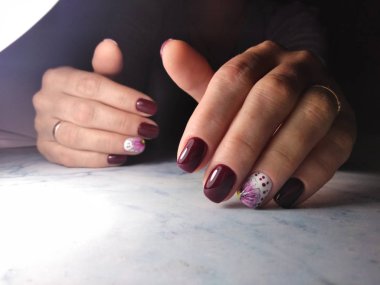 Ozan rengi ve beyaz çiçek tasarımı ile şık manikür