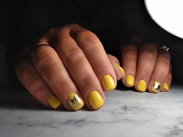 Manicure limpo em dedos grossos com gel amarelo polonês e ouro — Fotografia de Stock