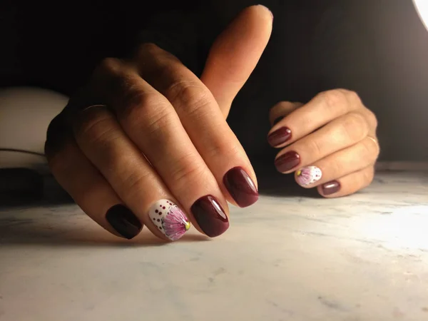 Manicura elegante con color bardo y diseño de flor blanca — Foto de Stock