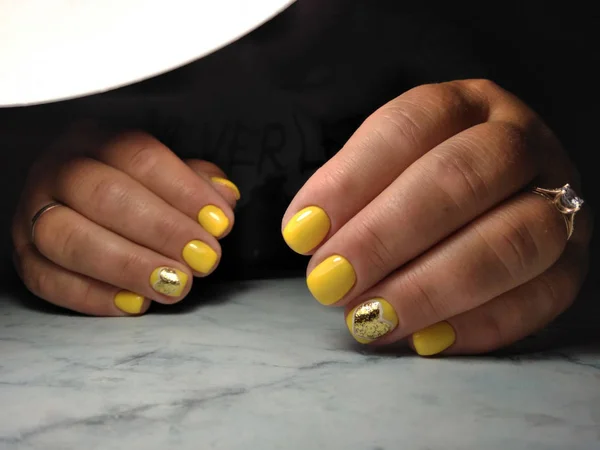Manicure pulita sulle dita spesse con smalto gel giallo e oro — Foto Stock