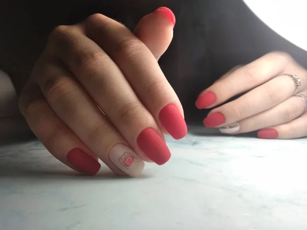 Matowy czerwony manicure z różowym designie i napisem — Zdjęcie stockowe