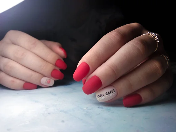 Manicure rosso opaco con disegno rosa e lettering — Foto Stock