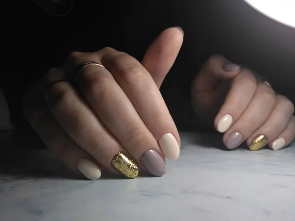 Manicure delicata con rivestimento grigio e beige e paillettes dorate — Foto Stock