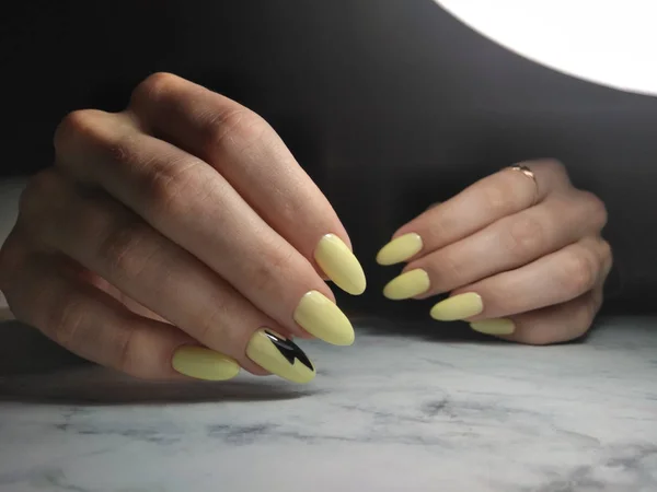 Manicure amarelo elegante com relâmpago preto — Fotografia de Stock
