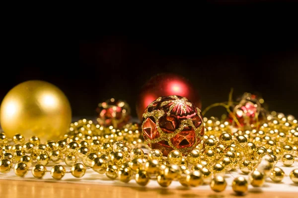 Kerst Speelgoed Met Kralen Tafel Een Zwarte Achtergrond Gouden Kralen — Stockfoto