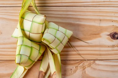 Ahşap arka planda ketupat torbalar