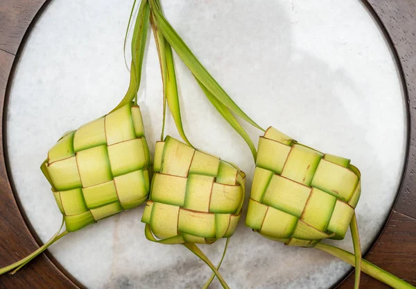 大理石の背景に Ketupat パウチ。Ketupat はダムダムズの一種です。 — ストック写真