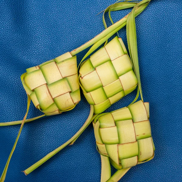 Ketupat påsar på en blå bakgrund. Ketupat är en typ av dumpl — Stockfoto