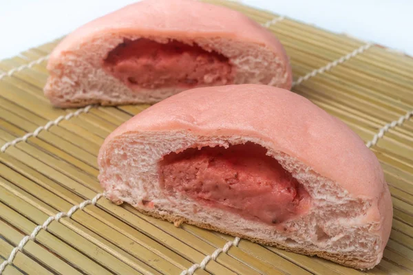 Japanese Snack - Pink Melon Pan on rattan mat. Strawberry Flavor