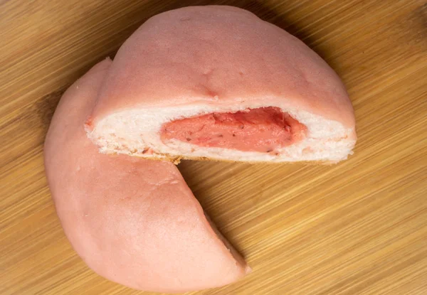 Japanese Snack - Pink Melon Pan, on wooden plate. Strawberry Fla