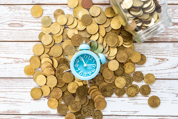 Ahorros para el futuro. Malasia monedas y reloj en respaldo de madera — Foto de Stock